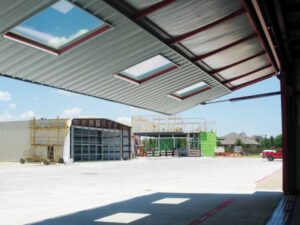 The underside of the hangar's hydraulic door, which features windows framed in red trim, shows the shade it can provide. 