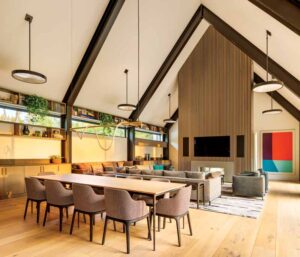 The open-concept living and dining room area features exposed steel bents in the ceiling.