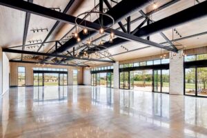 Glossy marble floors, large windows and exposed metal beams configure the ballroom.