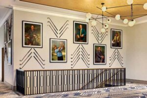 A wall in the conference area displays portraits of famous golfers as well as vintage golf clubs, arranged in an ornate pattern. 