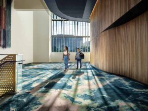 Students are shown walking through a carpeted hallway, and thought a sunny day, the sunshades are blocking the sun. 