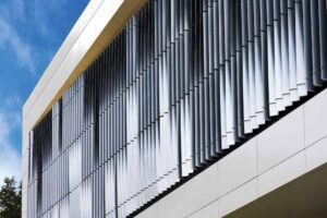 A diagonal close up of the sunshades on the exterior of the window, on a sunny day.