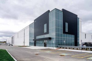Exterior of the building shows tall windows and Insulated metal panels in two contrasting colors and patterns. 