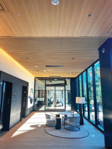 A lobby area showcases large windows, a seating area and the unique ceiling system. 