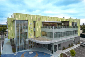 At the upper two floors of the Vietnamese American Service Center, vertical metal panels in a mixture of colors create a pattern designed to mimic bamboo forests in Vietnam.