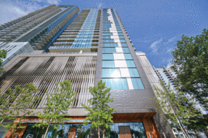 Shot from below, this is vertical look at this high-rise building leading up to the blue sky. 