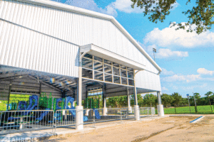 An exterior view of the steel framing and playground inside the structure. 