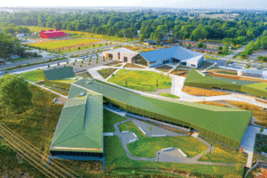 An aerial view of a long building, which sits in a farm field.