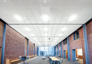 A horizontal view of the center shows enclosed ceilings, long tables and office chairs, with brick walls on both sides. 