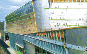 A close up view of the insulation on the exterior at the top of a car dealership building.