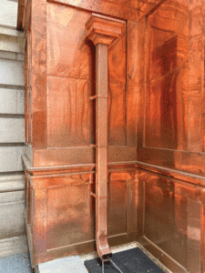 An up-close view of a copper downspout.