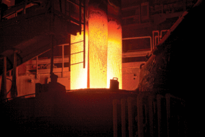 A dark, industrial area features a furnace glowing orange.