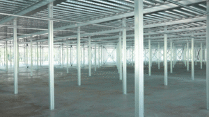 An empty storage space shows multiple vertical steel support beams and an open concept ceiling.