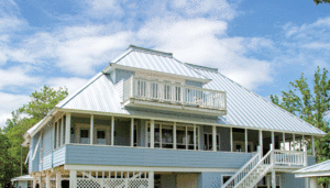 A close-up, horizontal view of a two-level, light blue metal roof. Each level features a deck or small balcony, accented with white trim and fencing. Blue sky with wispy clouds is in the background. 