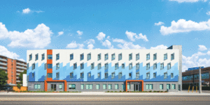 A horizontal view of a low-rise apartment building. The top panels are white, the middle section light blue, and the lower section another blue.