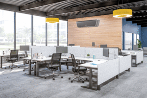 A view of an open concept work space with multiple white cubicles, The far back wall is a light-brown panelling, and the far left wall is all glass. the ceiling is made up of dark grey open concept venting.