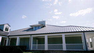 A close up view of the clubhouse shows the metal roof as well as a balcony trimmed with a white metal guard rail and pillars. 