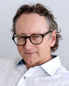 Headshot of distinguished white, bespectacled man with a receding hairline.