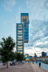 A full look at the tower at dusk. Tourists enjoy the boardwalk. 