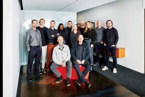 Ten team members stand side by side, two sit down in front.