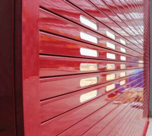 An up-close, angled shot of a glossy red rolling door.