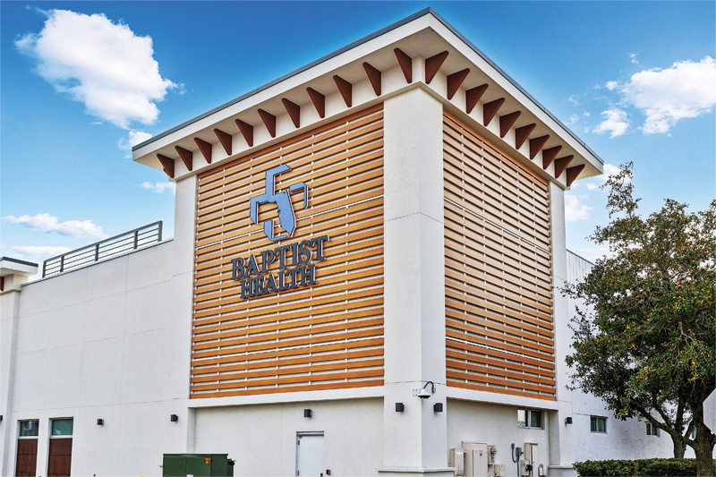 Metal slats act as cladding along a square corner structure that's part of a medical facility.