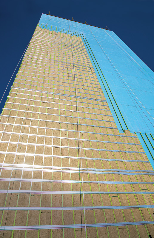 An under-construction hotel with panels being installed for insulation.