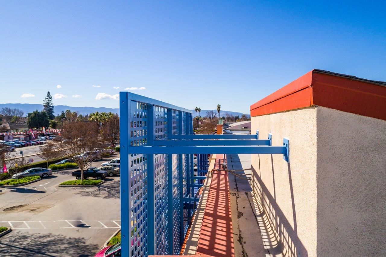Bars supports a metal grill sign and attach it to the side of a discount store building. To the left is an empty parking lot.