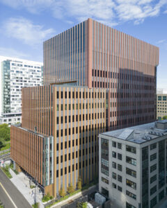Smooth panel exterior of tall building with reddish-brown brick