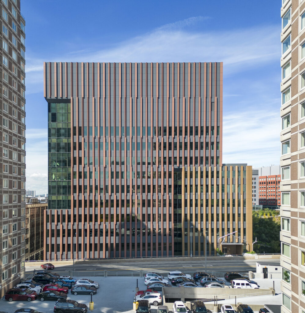 Smooth panel exterior of tall building with reddish-brown brick