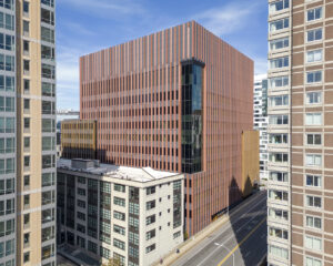 Smooth panel exterior of tall building with reddish-brown brick