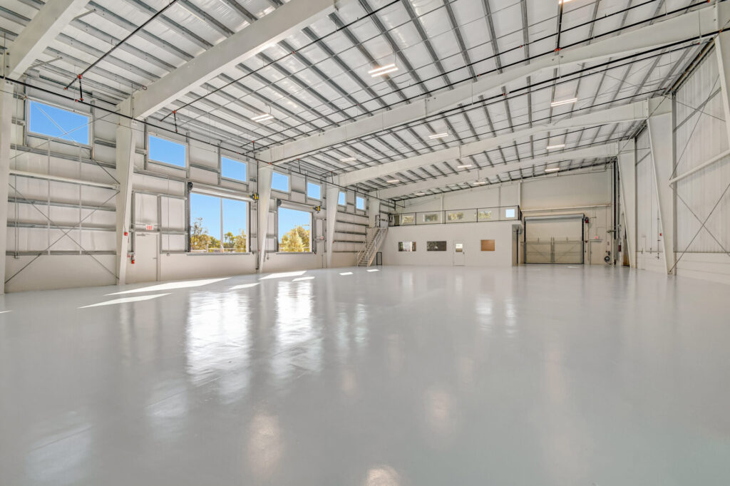 Interior of hangar garage featuring metal framing and white floors, walls, and ceiling.