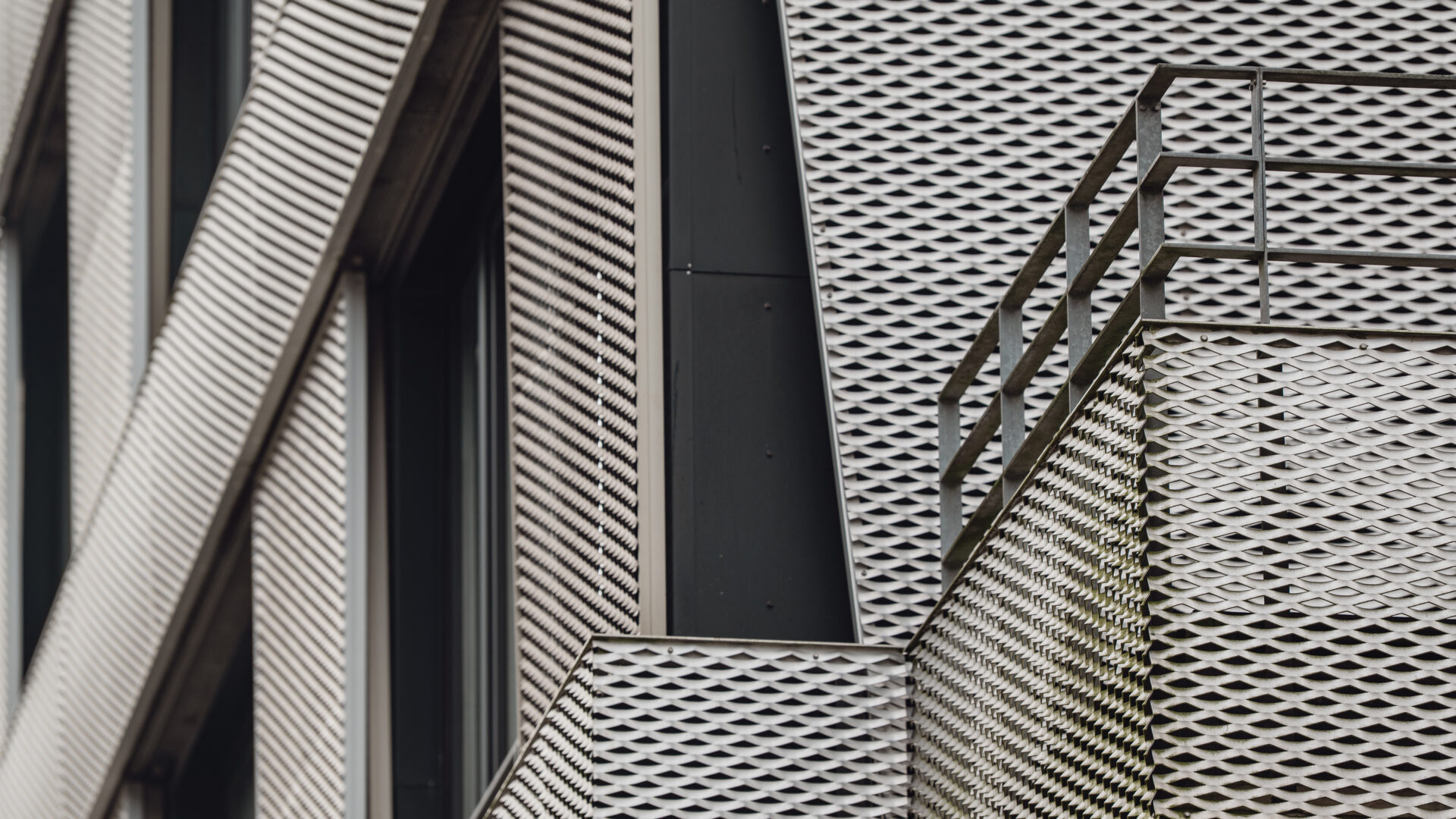 Facade with balcony and expanded metal panels