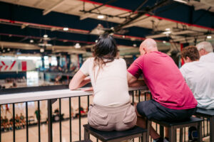 People sit on bar stools at drink rail.