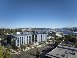 Blue sky and overhead view of large office building with metal facade.