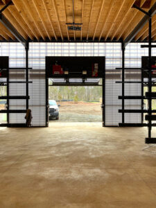 Interior view of boathouse, featuring open bifold door and metal framing.