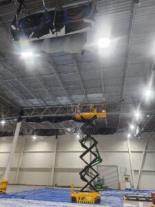 Tall industrial lift visible inside manufacturing facility demonstrating a solution for metal ceiling corrosion.