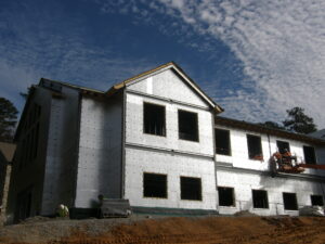 Exterior view of a house under construction with layer of the building envelope visible.