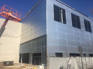 Foil facing on exterior of an in-progress building project, photographed during the daytime.
