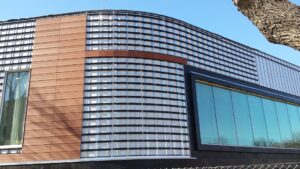 Sideview of building with cladding installed over polyiso, taken during the daytime.