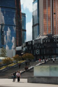 In a city, a combination of stone and metal buildings are visible.