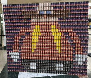 Can structure of man in red shirt with prominent moustache.