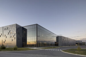 Eye-catching reflective facade of dark paneled structure at dusk.