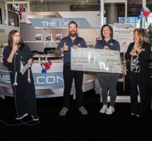 The presentation of a large cheque, four people in the picture.