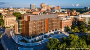 Overhead side street view of the large scale rectangular geometric structure, positioned on a street corner.