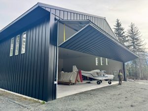 Open bifold door on an all-black corrugated metal structure
