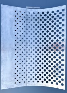 A pattern of rounded perforations on a metal panel.