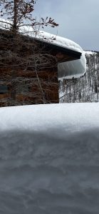 Snow on top of and surrounding a residence.