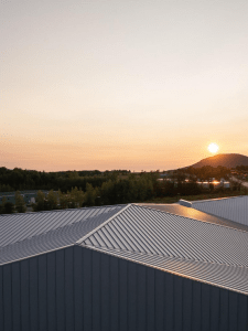 Sunrise visible over an angular standing seam steel roof.
