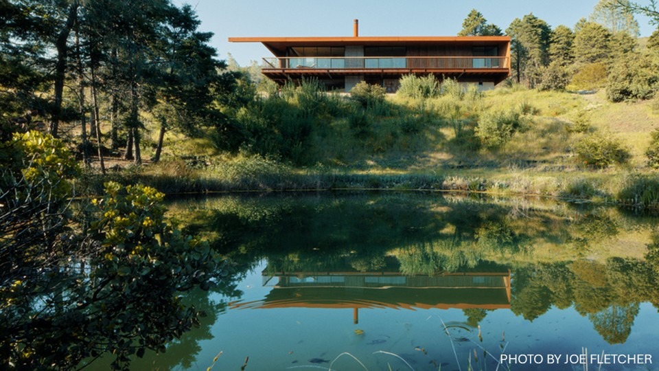 Front view of the pine flat residence with a pond